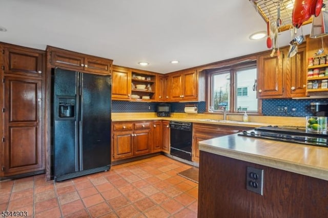 kitchen with open shelves, light countertops, decorative backsplash, and black appliances