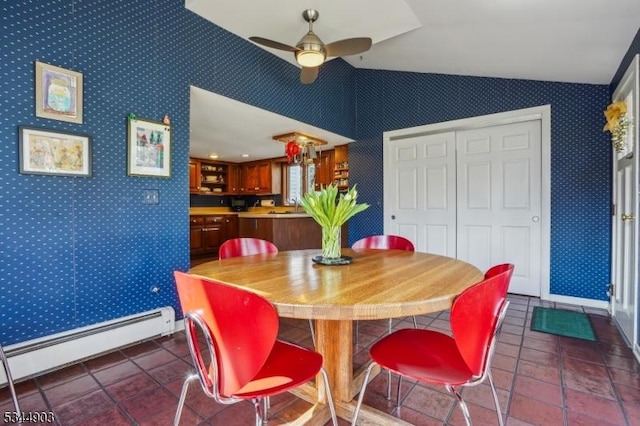 dining area with baseboard heating, wallpapered walls, ceiling fan, lofted ceiling, and dark tile patterned floors