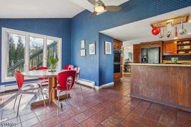dining area featuring baseboards, lofted ceiling, wallpapered walls, ceiling fan, and a baseboard radiator