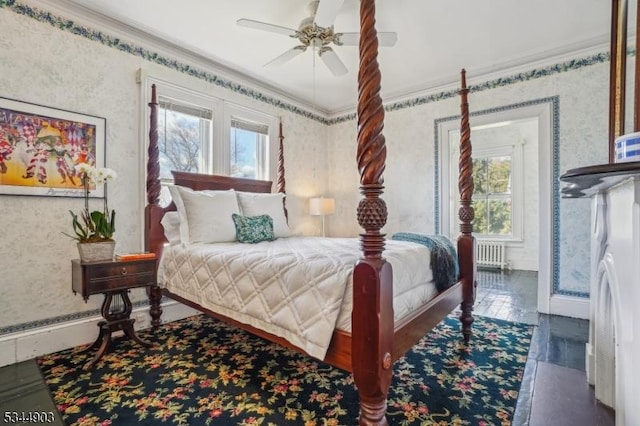 bedroom with radiator heating unit, wallpapered walls, and multiple windows