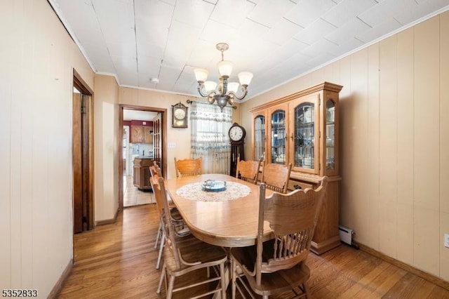 76 Kossuth St, Newark City, NJ 07105 - dining area featuring a chandelier, light wood-type flooring, ornamental molding, a baseboard heating unit, and baseboards