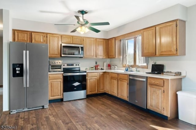 kitchen featuring a ceiling fan, a toaster, appliances with stainless steel finishes, light countertops, and dark wood-style flooring