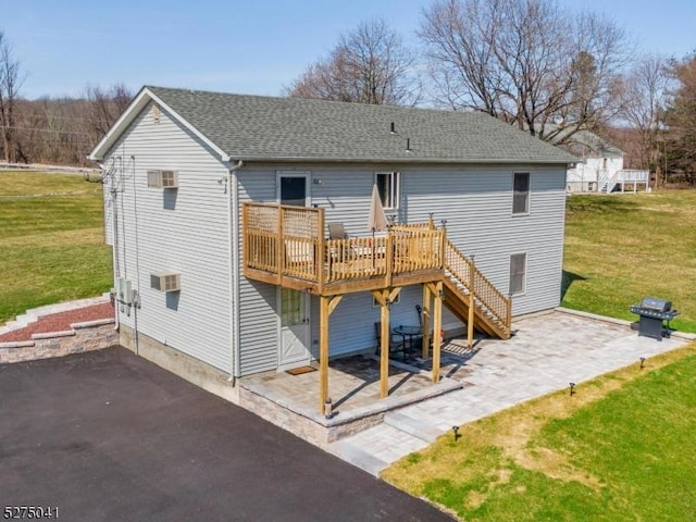 back of house featuring stairway, a lawn, a deck, and a patio