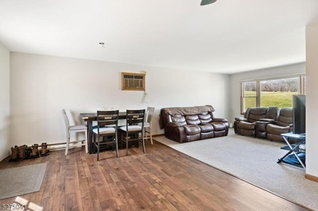 living room featuring baseboards, wood finished floors, and a wall mounted AC