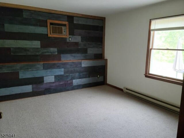 spare room with baseboard heating and carpet