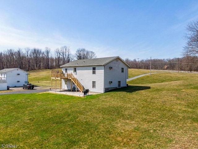rear view of property with a wooden deck, a lawn, and stairway