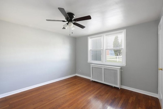 unfurnished room featuring radiator heating unit, baseboards, ceiling fan, and dark wood finished floors
