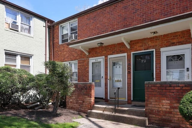 entrance to property with brick siding and cooling unit