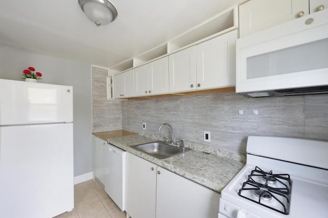kitchen with a sink, white cabinets, white appliances, and light tile patterned flooring