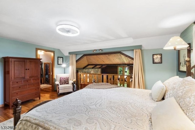 bedroom with wood finished floors and vaulted ceiling