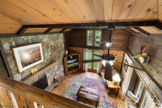 living room featuring wood ceiling, wood finished floors, wooden walls, and beam ceiling