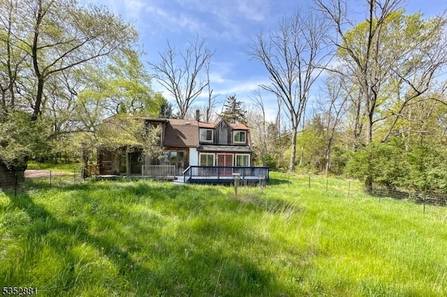 back of property featuring a gambrel roof and a deck