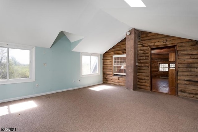 bonus room featuring carpet, rustic walls, and lofted ceiling