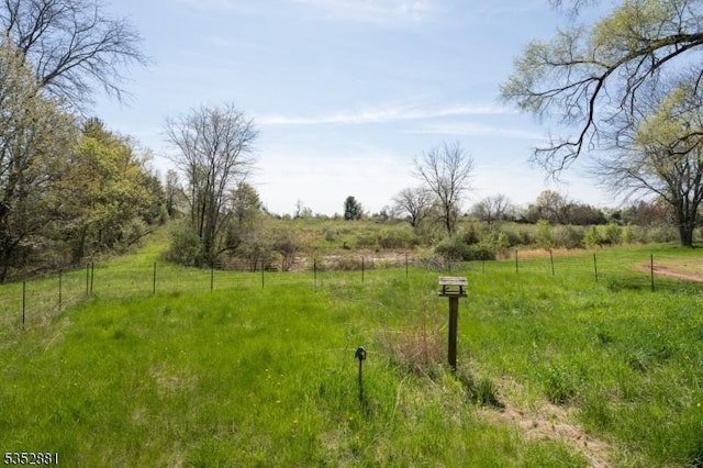 view of yard featuring fence and a rural view