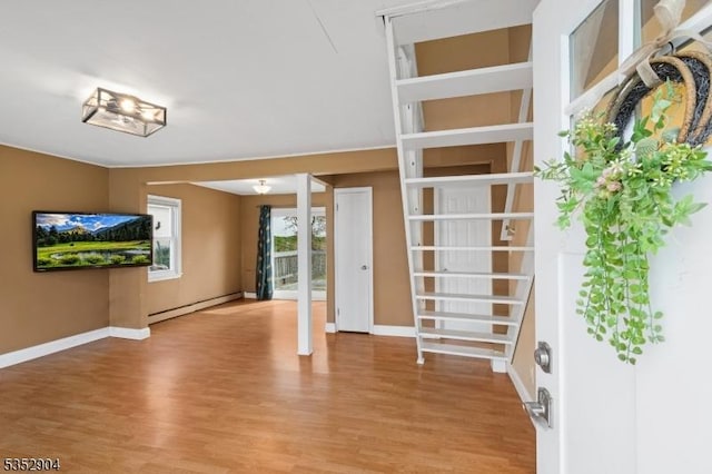 unfurnished living room with baseboards, baseboard heating, and light wood-style flooring