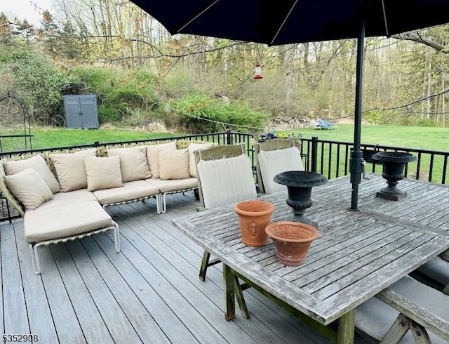 wooden terrace featuring a yard, an outdoor hangout area, and a forest view