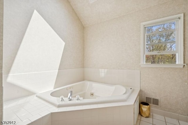 full bath featuring tile patterned floors, vaulted ceiling, visible vents, and a jetted tub