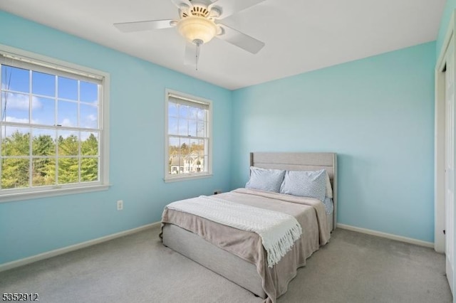 carpeted bedroom featuring baseboards and a ceiling fan