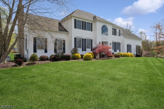 back of property featuring a lawn and a shingled roof
