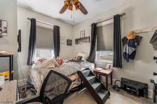 bedroom featuring carpet, baseboards, a ceiling fan, and multiple windows