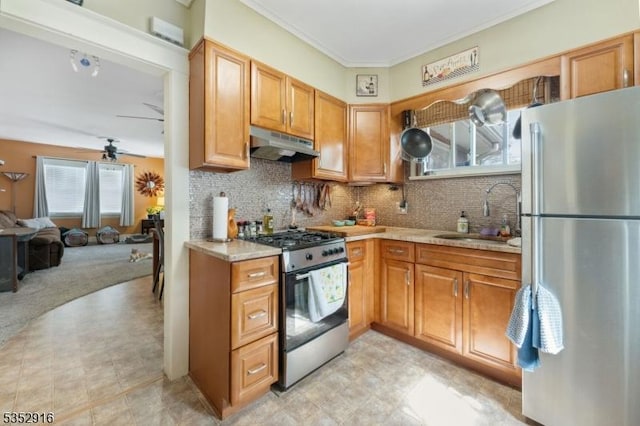 kitchen featuring under cabinet range hood, appliances with stainless steel finishes, light countertops, ceiling fan, and a sink