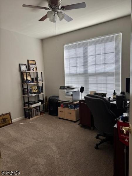 carpeted office featuring ceiling fan