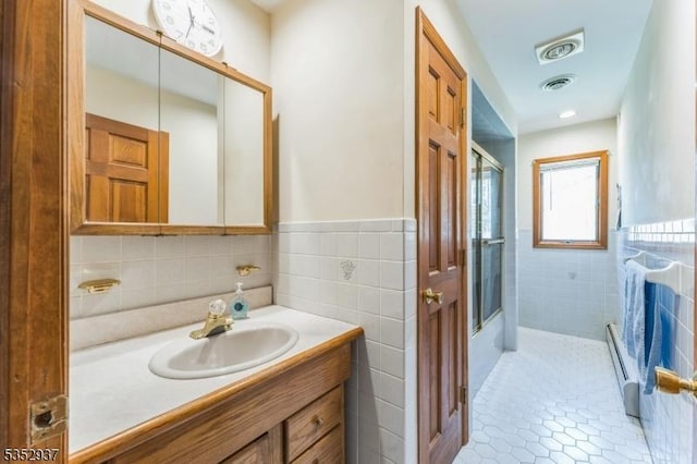 bathroom featuring tile patterned flooring, tile walls, visible vents, and vanity