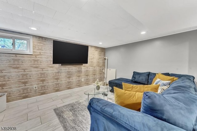 living area featuring recessed lighting, an accent wall, and wooden walls