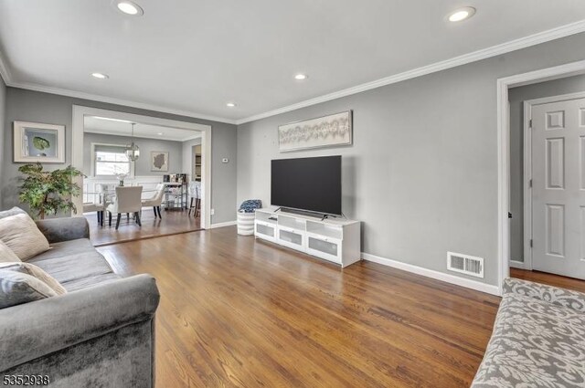living room featuring crown molding, recessed lighting, and visible vents