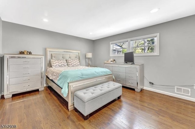 bedroom featuring baseboards, recessed lighting, wood finished floors, and visible vents