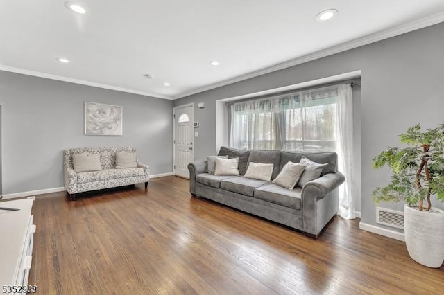 living room with crown molding, recessed lighting, baseboards, wood finished floors, and visible vents