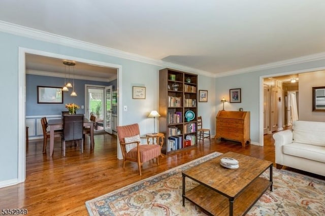 living area with crown molding and wood finished floors