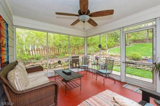 sunroom / solarium featuring a healthy amount of sunlight and a ceiling fan