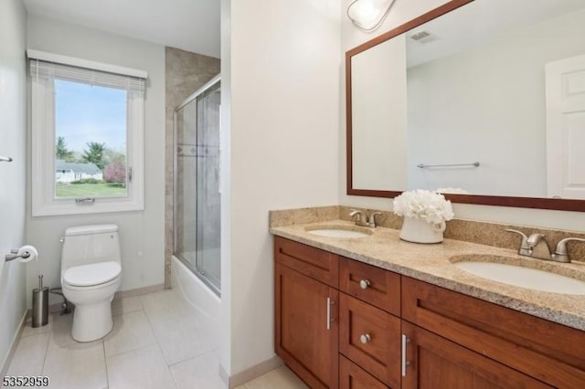 full bathroom featuring double vanity, toilet, tile patterned flooring, and a sink
