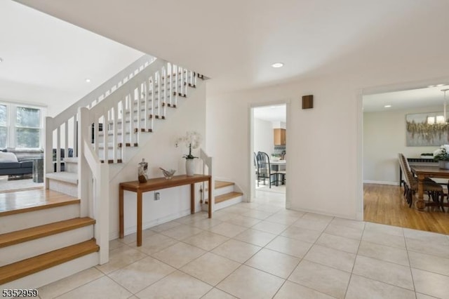 stairs with tile patterned floors, an inviting chandelier, recessed lighting, and baseboards