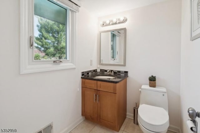 bathroom featuring baseboards, toilet, tile patterned flooring, and vanity