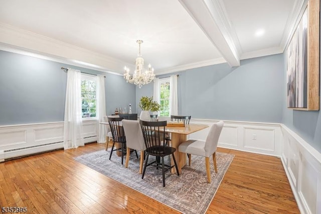 dining area featuring a wealth of natural light, ornamental molding, light wood-type flooring, and a chandelier