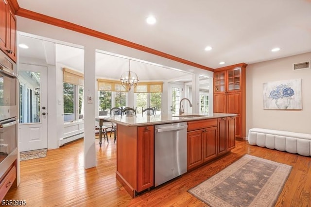 kitchen with stainless steel dishwasher, ornamental molding, a kitchen island with sink, a chandelier, and a sink
