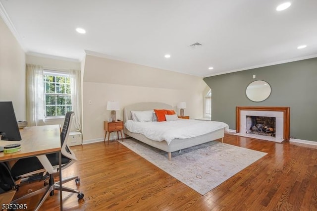 bedroom with ornamental molding, recessed lighting, wood finished floors, and visible vents