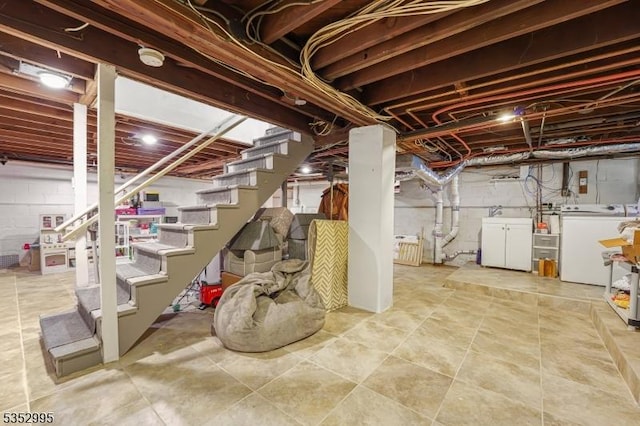 unfinished basement featuring stairway and separate washer and dryer
