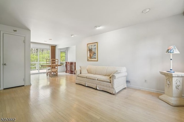 living area with baseboards and light wood-style flooring