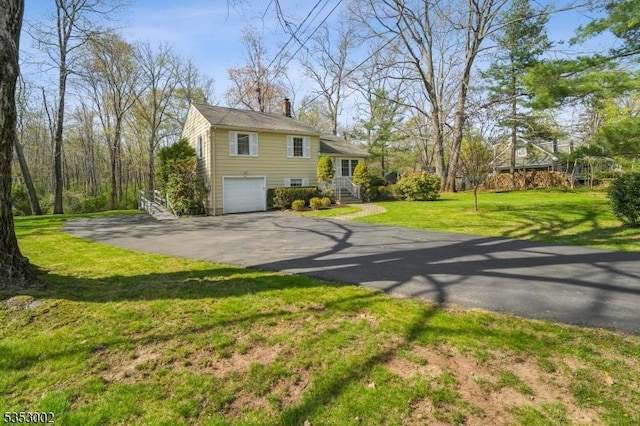 view of property exterior with a garage, a chimney, a lawn, and driveway