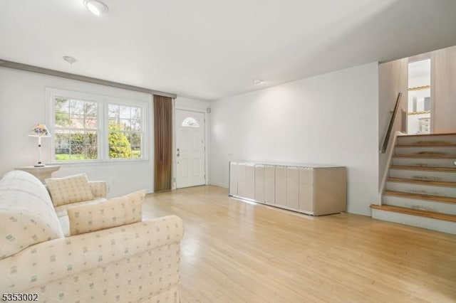living area with stairs and wood finished floors