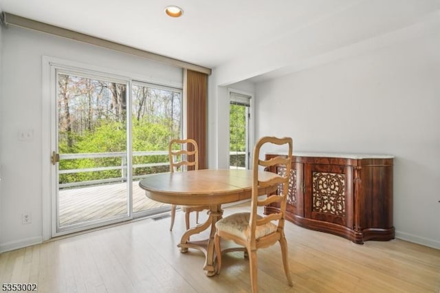 dining space with baseboards and light wood finished floors
