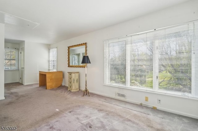 unfurnished living room featuring carpet flooring, baseboards, and visible vents