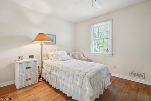 bedroom with ceiling fan, baseboards, visible vents, and wood finished floors