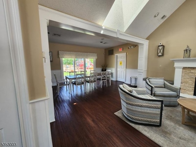 living area featuring wood finished floors, lofted ceiling, and a fireplace