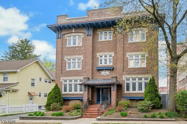 view of front of house with fence and brick siding