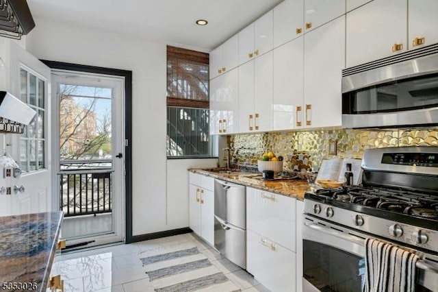 kitchen with recessed lighting, dark stone counters, decorative backsplash, stainless steel appliances, and a sink