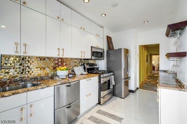 kitchen featuring recessed lighting, stainless steel appliances, marble finish floor, light stone counters, and backsplash